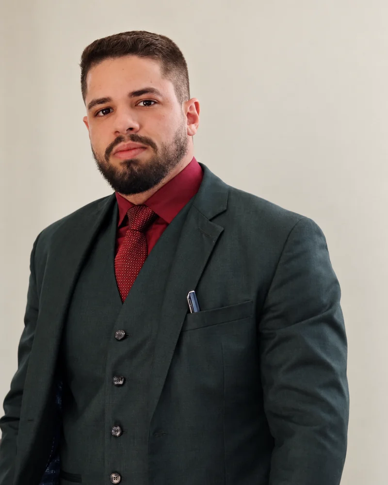 Matheus Kehl, advogado, de terno e camisa vinho no escritório